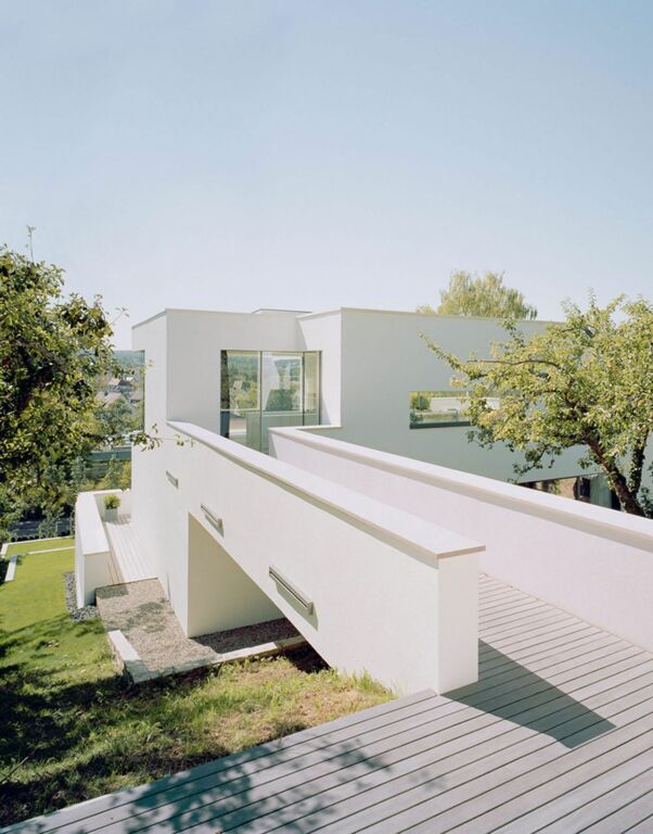 Wooden terrace with footbridge and wall to residential house