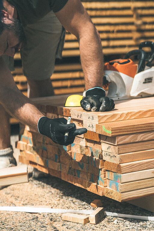 Mitarbeiter im Sägewerk bei der Zusammenstellung von Terrassendielen