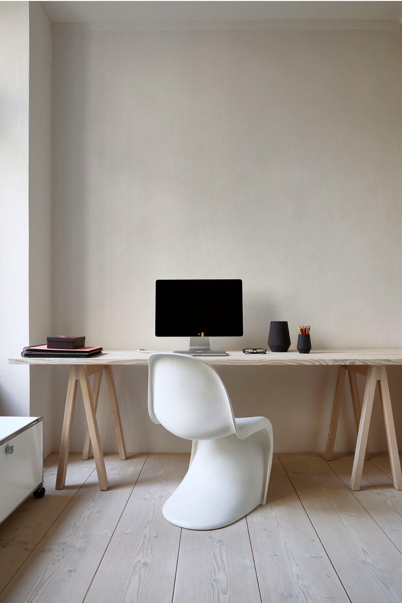 Helles Arbeitszimmer mit Schreibtisch und Fußboden aus hellem Douglasienholz mit Panton Chair und Bildschirm