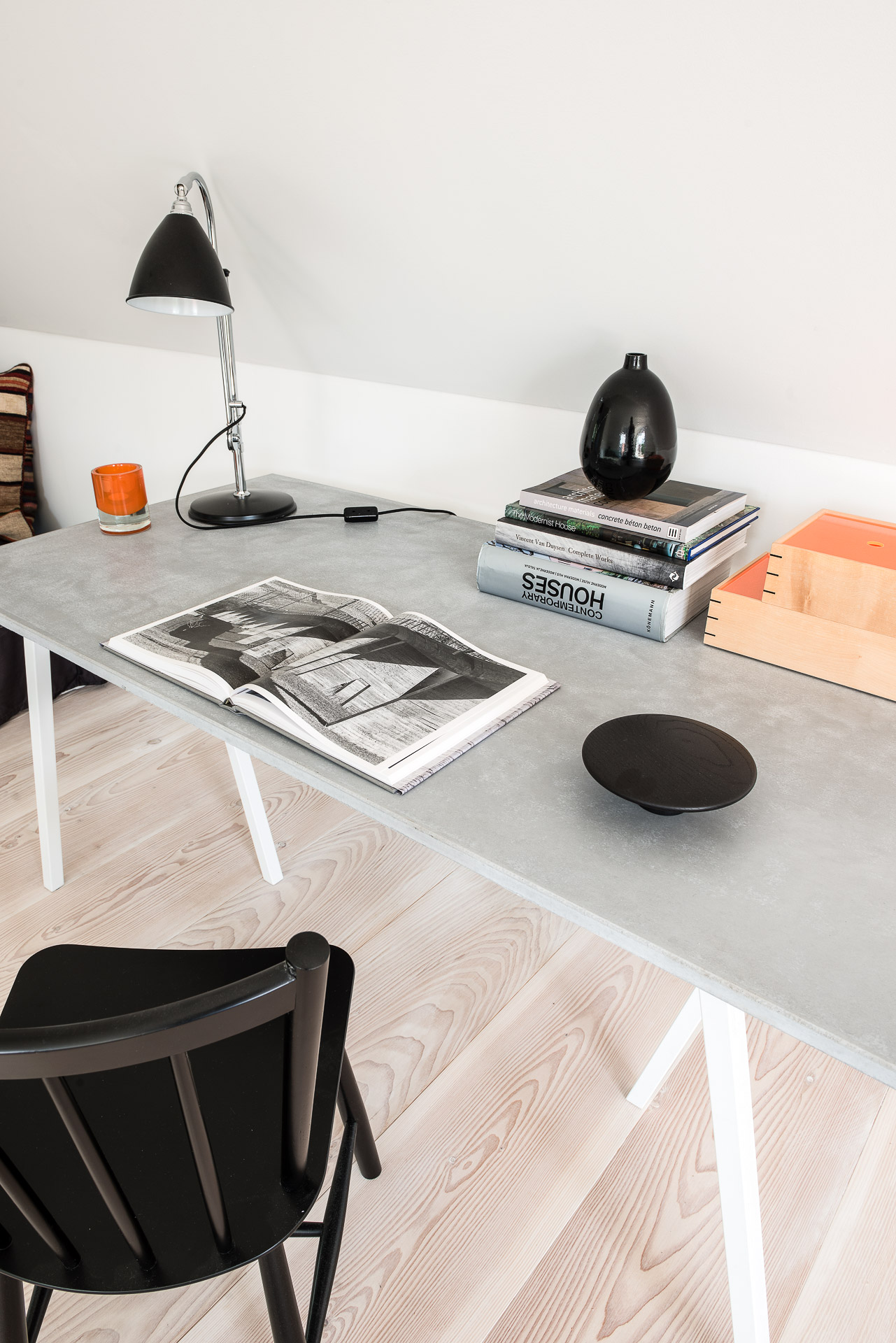 Schreibtisch in Home Office mit hellem Dielenboden und schwarzem Stuhl