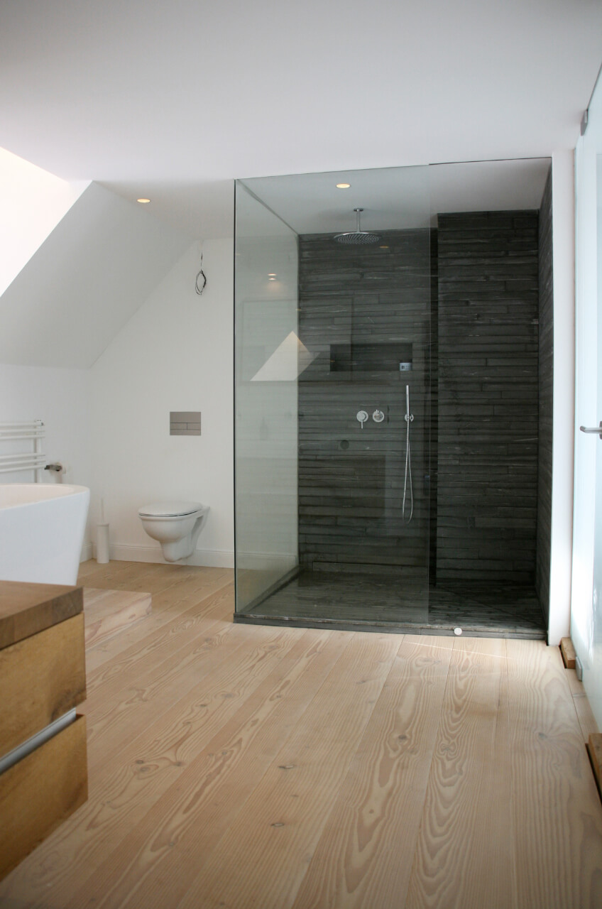 Bad mit bodenebener Dusche und Dielenboden aus hellem Holz