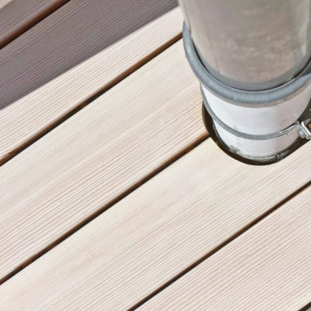 Detailausschnitt der Terrassendielen mit ausgespartem Platz für Abflussrohr