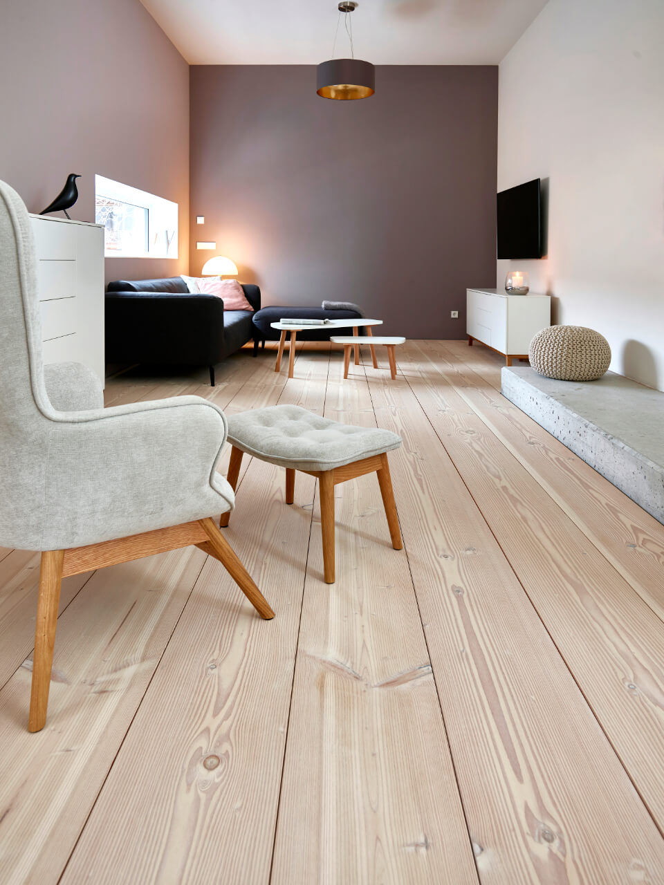 Wohnzimmer mit hellen Möbeln und hellem Holzboden mit langen, gemaserten Dielen